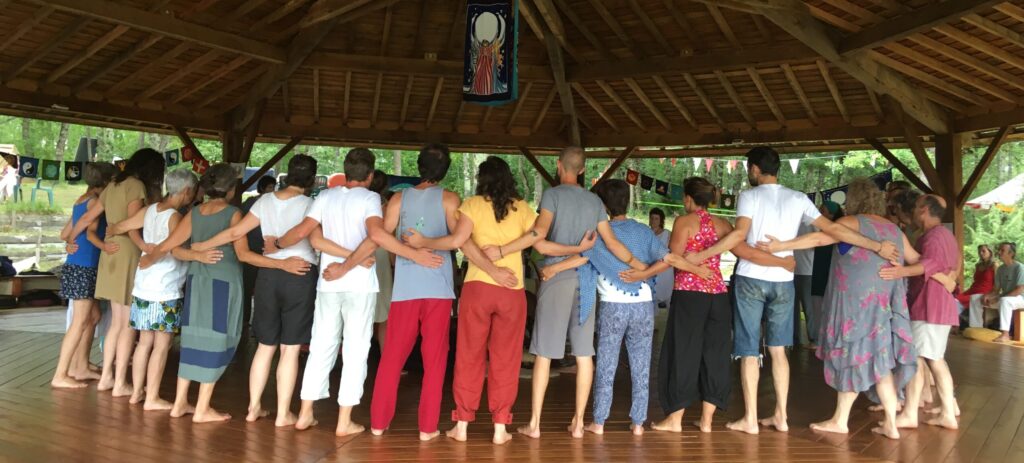 A circle of dancers at a Dances of Universal Peace gathering, representing the global community and spiritual lineage.
